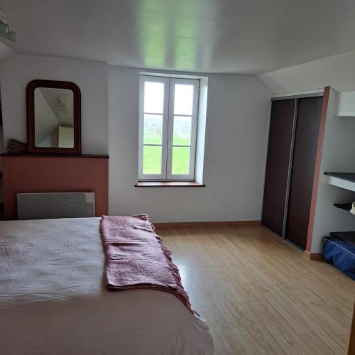 une chambre avec un grand lit et un miroir dans l'établissement Maison de charme en campagne, 5 min du haras du pin, à Nonant-le-Pin