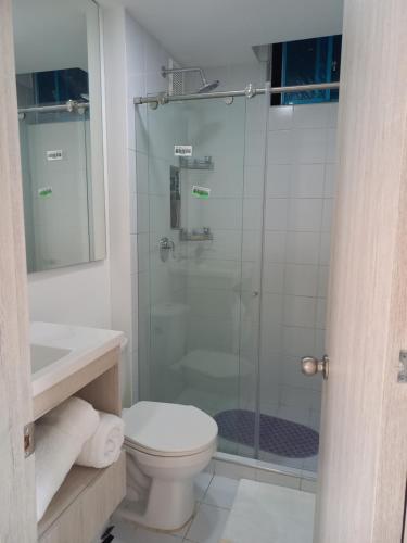 a bathroom with a toilet and a glass shower at Reserva del Peñón Girardot - Apartamento Vacacional Familiar Confort La Esmeralda in Girardot