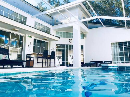 a swimming pool in front of a house at Private Pool With Heat - Close to Disney! in Kissimmee