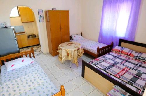 a small room with two beds and a table at Kalemi Sunrise Studios in Borsh