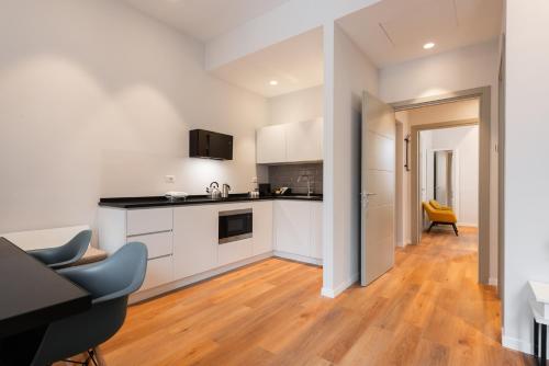 a kitchen with white cabinets and a wooden floor at Major House - Luxury Apartments in Rome by Hostand in Rome