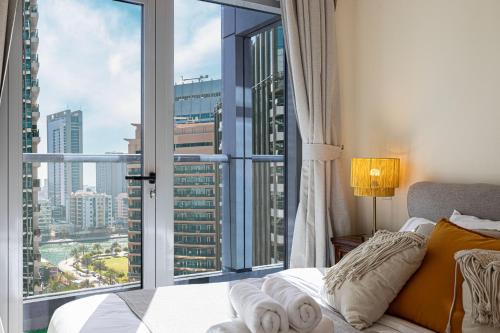 ein Schlafzimmer mit einem Bett und einem großen Fenster in der Unterkunft Stylish 3 bedrooms Boho-Style Home in Dubai