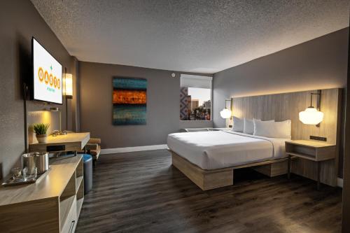 a hotel room with a bed and a desk at Oasis at Gold Spike in Las Vegas
