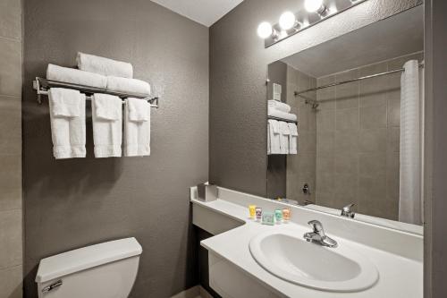 a bathroom with a sink and a toilet and a mirror at Oasis at Gold Spike in Las Vegas