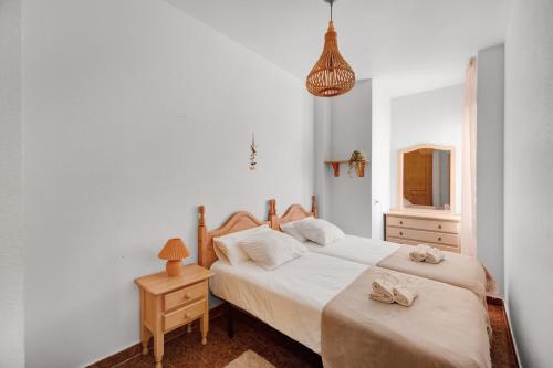a bedroom with two beds and a table and a lamp at A spacious and cozy apartment. in Torrevieja