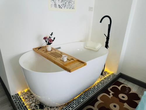 eine Badewanne mit einem Tablett aus Holz darüber in der Unterkunft The most prosperous seaside seaview apartment in Jomtien(Tub, high speed Wi-Fi, Projector) in Jomtien Beach