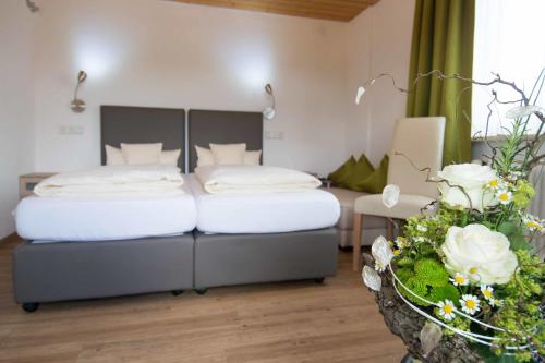 a bedroom with a bed and a table with flowers at Wellnesshotel Sonnenhof & Sonnhalde in Ühlingen-Birkendorf