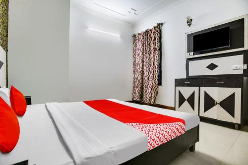 1 dormitorio con 1 cama y TV de pantalla plana en OYO Flagship Hotel Vivek Plaza en Ambāla