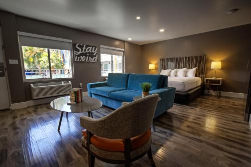 a hotel room with a blue couch and a bed at Oasis at Gold Spike - Adults Only in Las Vegas