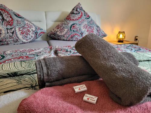 uma cama com almofadas e uma pilha de cobertores em Mandelas Cozy Lounge em Schmelz