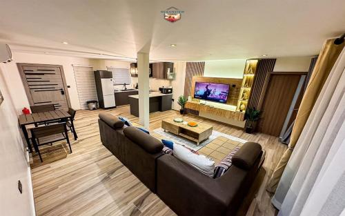uma sala de estar com um sofá e uma televisão em Newly Built Luxury Beachfront Villa em Acra
