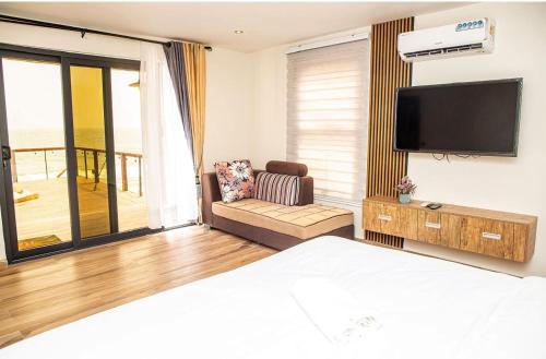 um quarto de hotel com uma cama e uma televisão de ecrã plano em Newly Built Luxury Beachfront Villa em Acra