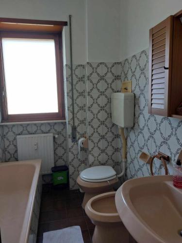 a bathroom with a toilet and a sink and a tub at #Punto FM 2# in Marghera