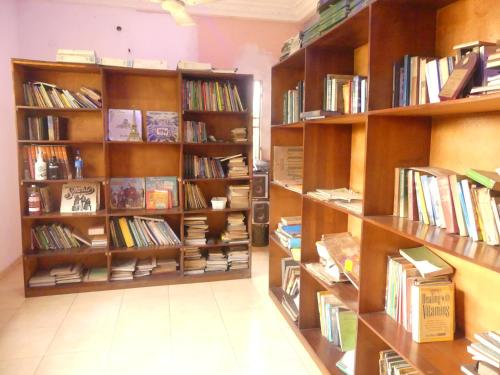 a library with wooden shelves filled with books at Templar's court in Port Harcourt