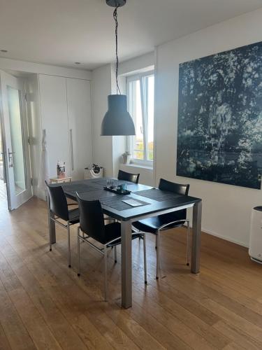 uma mesa de jantar com cadeiras e um quadro grande em Casa Bolero em Horgen