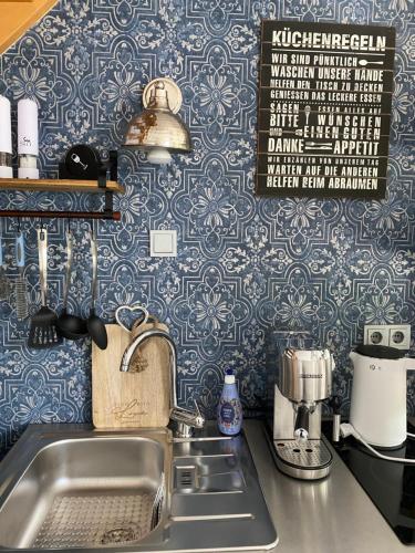a kitchen counter with a sink and blue wallpaper at Ferienwohnung Elisabeth in Blankenhain