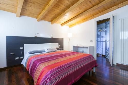 1 dormitorio con 1 cama grande con una manta colorida en Semplicemente Casa, en Milán