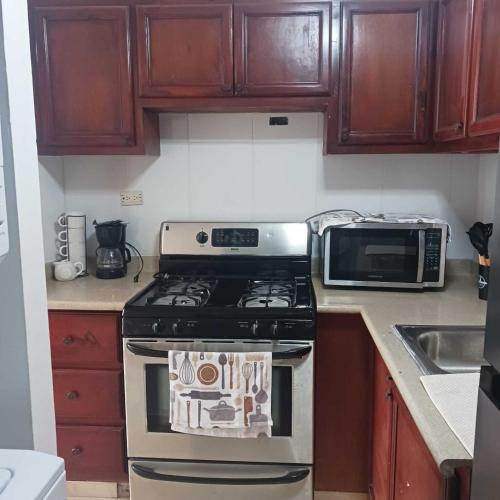a kitchen with a stove and a microwave at Ocean Breeze Apartment in La Romana in La Romana