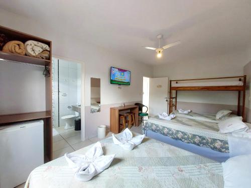a hotel room with two beds and a bathroom at Pousada Pompeia in Socorro