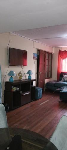 a living room with a couch and a flat screen tv at Mi casa tu casa. My house in La Paz