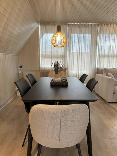 a dining room table and chairs in a room at Cabin in Lava Village with hot tub in Selfoss
