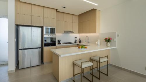 a kitchen with a counter with stools and a refrigerator at Beautiful View! Costa Divina B4 by Kivoya in Puerto Peñasco