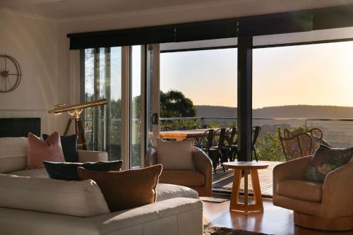 a living room with couches and a large glass window at Queensberry Hill View- luxury group retreat in Daylesford