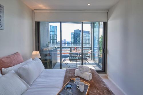 a living room with a couch and a large window at High-Rise on Collins with Free Parking, Pool, Gym in Melbourne