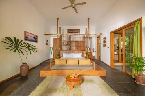 a living room with a bed and a table at Green Bay Phu Quoc Resort & Spa in Phú Quốc