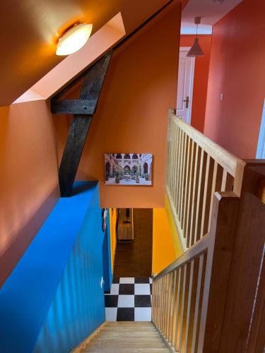 - un couloir avec des murs colorés et des escaliers dans une maison dans l'établissement GITES au calme, à Soudan