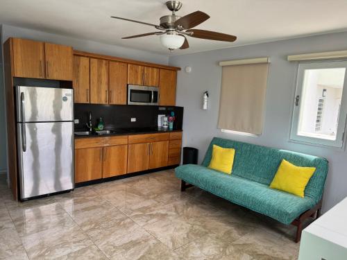 a living room with a green couch and a refrigerator at Villa Ensenada Honda in Culebra