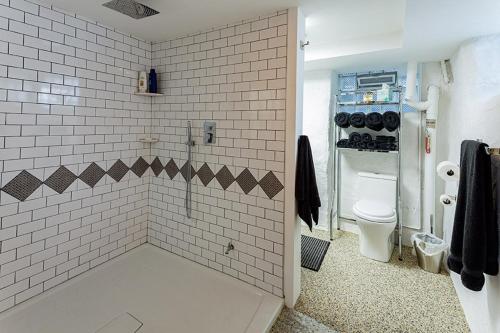 uma casa de banho com um chuveiro de azulejos brancos e um WC. em Mike & Allen's Place on the Park_3 em Columbus