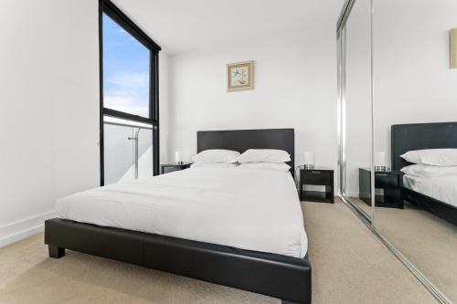 a bedroom with a large bed and a large mirror at Bright 1-Bed by Natural Reserves with Pool & Gym in Harrison