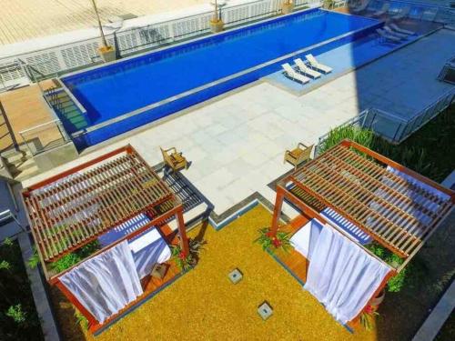 una vista aérea de una piscina con dos bancos en Apartamento Dfplaza luxo, en Brasilia