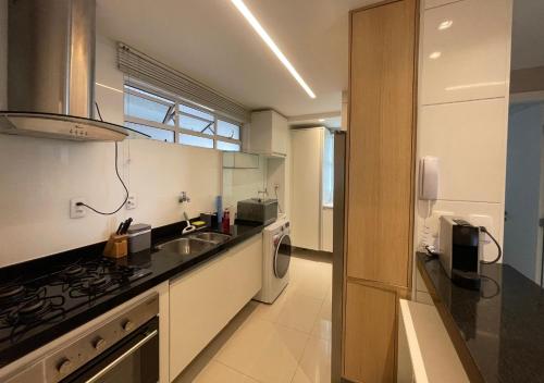 a kitchen with a sink and a stove at Conforto Na Melhor Localização Com Vista Mar in São Luís