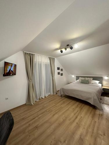 a bedroom with a bed and a large window at Apartments Green Linden in Rakovica