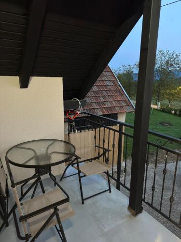 a patio with a glass table and chairs on a balcony at Apartments Green Linden in Rakovica