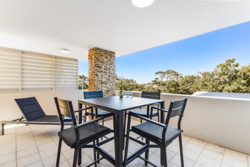 a dining room with a table and chairs on a balcony at Redvue Holiday Apartments in Redcliffe