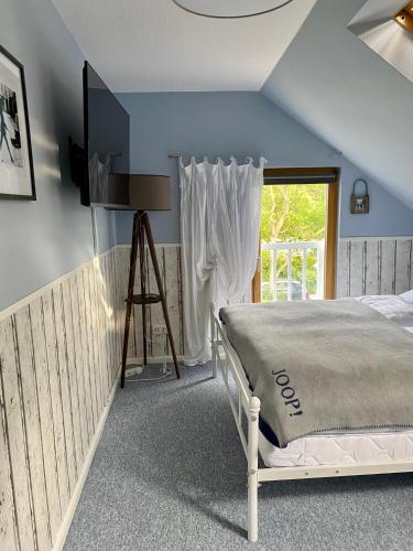 a bedroom with a bed and a window at Ferienwohnung Elisabeth in Blankenhain