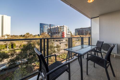 balcón con mesa, sillas y vistas en Central 1-Bed with Parking BBQ and Indoor Pool, en Canberra