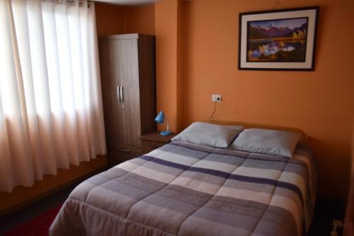 a bedroom with a bed and a picture on the wall at Saga Andina II in Cusco