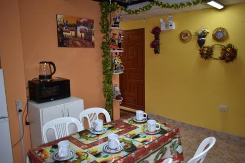a dining room with a table and chairs and a microwave at Saga Andina II in Cusco