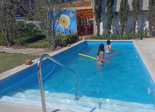 two children playing in a swimming pool at Cabañas Elsa María, Cabañas para Hospedaje con Alberca y Jardín de Eventos in Atlautla