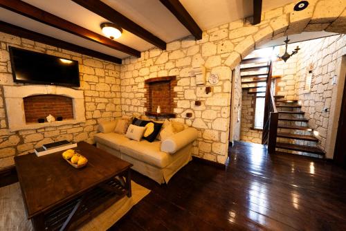 a living room with a couch and a stone wall at Aleysim Alaçatı-Design Als in Alaçatı