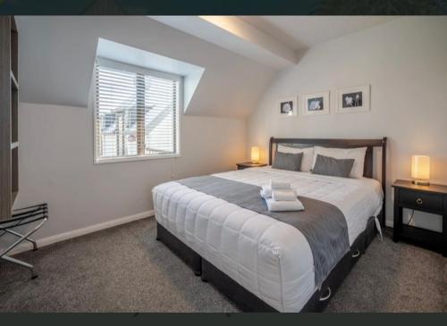 Un dormitorio con una cama grande y una ventana en Apartment 51 Akaroa en Akaroa