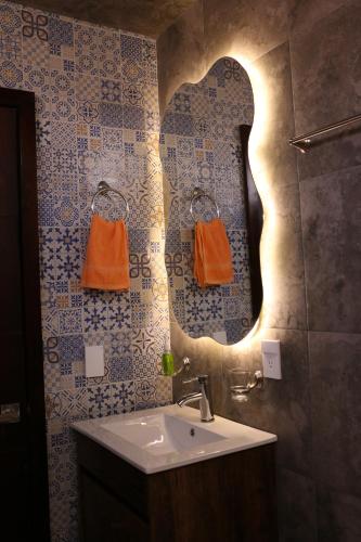 a bathroom with a sink and a mirror at La Cuadra Cabaña 2 in Zacatlán