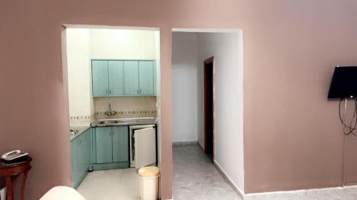 an empty kitchen with green cabinets and a refrigerator at Atlantis in Nouakchott