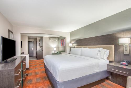 a hotel room with a large bed and a flat screen tv at Holiday Inn Express Shawnee by IHG in Shawnee