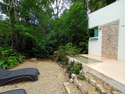a black bench sits in front of a house at Villa Ixchel private pool in Tulum