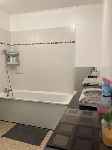 La salle de bains est pourvue d'une baignoire blanche. dans l'établissement Appartement T2 Cozy avec Parking, à Argenteuil